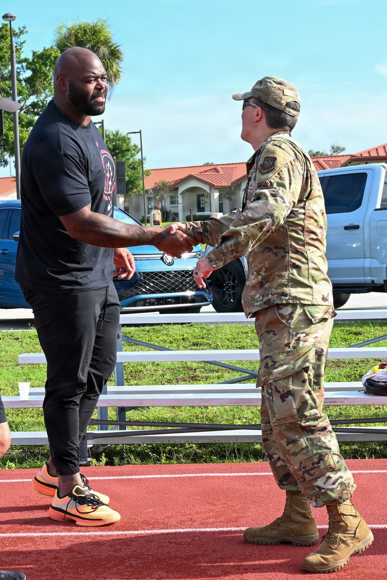 U.S. Air Force Col. BJ Lim, 6th Mission Support Group commander, greets A’Shawn Robinson, Tampa Bay Buccaneers defensive end, on MacDill Air Force Base, Florida, July 25, 2026. Robinson hosted the NFL Football Procamp to support the local military community and provide fundamental coaching to dependents. (U.S. Air Force photo by Airman 1st Class Alexis McDonnell)
