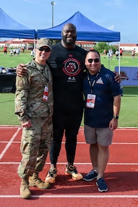 U.S. Air Force Col. BJ Lim, 6th Mission Support Group commander, right, A’Shawn Robinson, Tampa Bay Buccaneers defensive end, middle, and Andrew Defelice, MacDill Base exchange manager, pose for a photo during the Prosports NFL Football camp on MacDill Air Force Base, Florida, July 25, 2026. Robinson hosted the NFL Football Procamp to support the local military community and provide fundamental coaching to dependents. (U.S. Air Force photo by Airman 1st Class Alexis McDonnell)