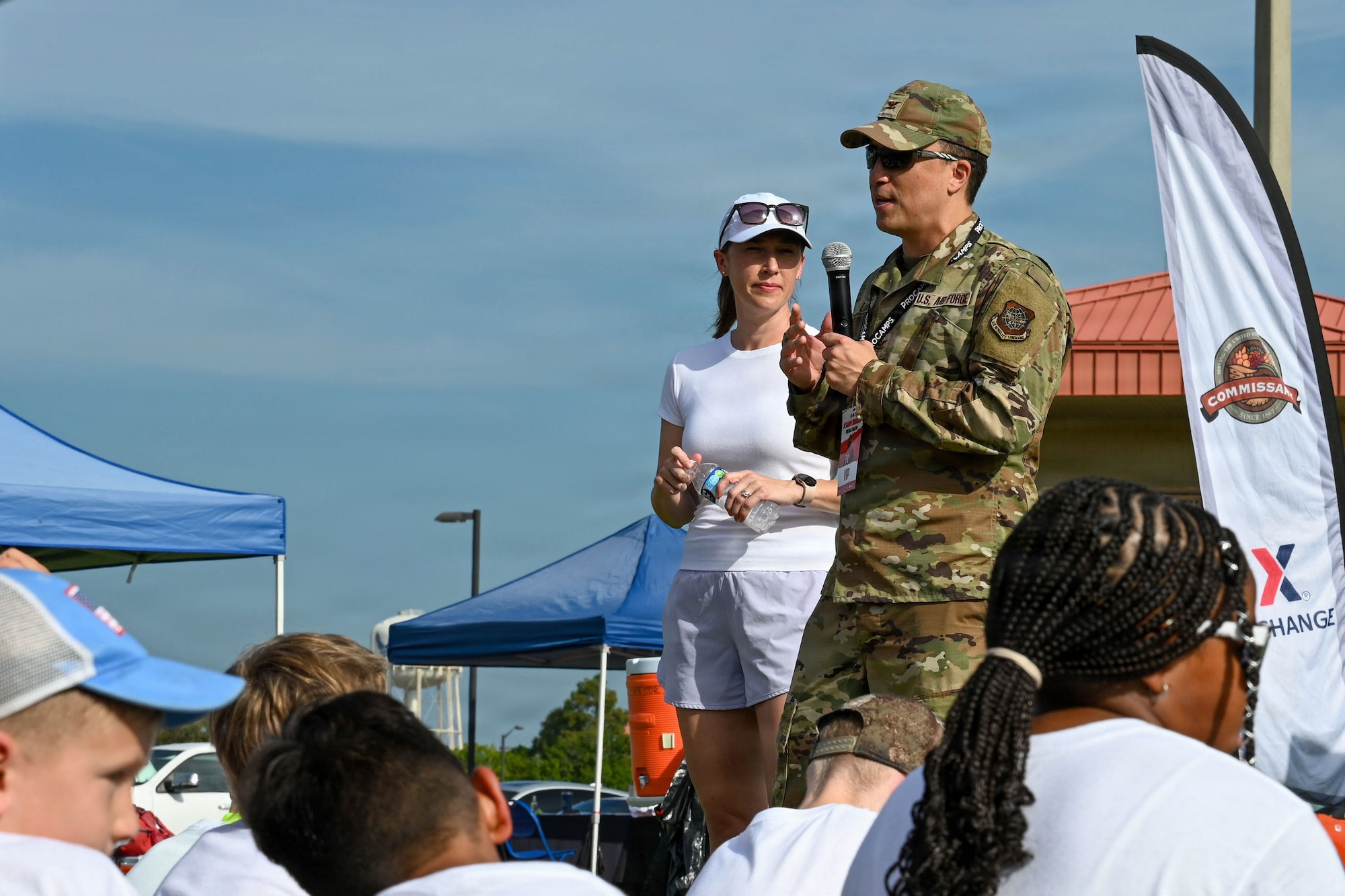 Jennifer Lim, military spouse, right, and U.S. Air Force Col. BJ Lim, 6th Mission Support Group commander, give opening remarks during the NFL Football Procamp hosted on Macdill Air Force Base, Florida, July 25, 2026. The football camp was hosted by A’Shawn Robinson, Tampa Bay Buccaneers defensive end, to support local military families and provide fundamental coaching. (U.S. Air Force photo by Airman 1st Class Alexis McDonnell)