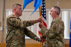 men in military uniform hold flag