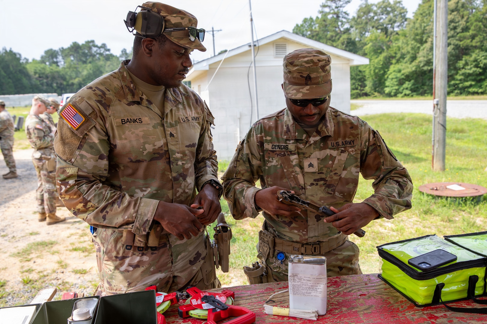 (From right) U.S. Army Sgts. Kirk Banks and McClifford Genois, military police, 273rd Military Police Company, 372nd Enhanced Military Battalion, 260th Special Purpose Brigade, applies cleaner, lubricant and preservative (CLP) on a pistol before conducting marksmanship training at Fort A.P. Hill, Virginia, July 28, 2026. This training was part of a multi-day advanced marksmanship exercise focused on enhancing individual and team weapons proficiency while preparing soldiers for contingency operations.