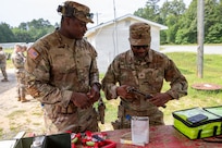 (From right) U.S. Army Sgts. Kirk Banks and McClifford Genois, military police, 273rd Military Police Company, 372nd Enhanced Military Battalion, 260th Special Purpose Brigade, applies cleaner, lubricant and preservative (CLP) on a pistol before conducting marksmanship training at Fort A.P. Hill, Virginia, July 28, 2026. This training was part of a multi-day advanced marksmanship exercise focused on enhancing individual and team weapons proficiency while preparing soldiers for contingency operations.