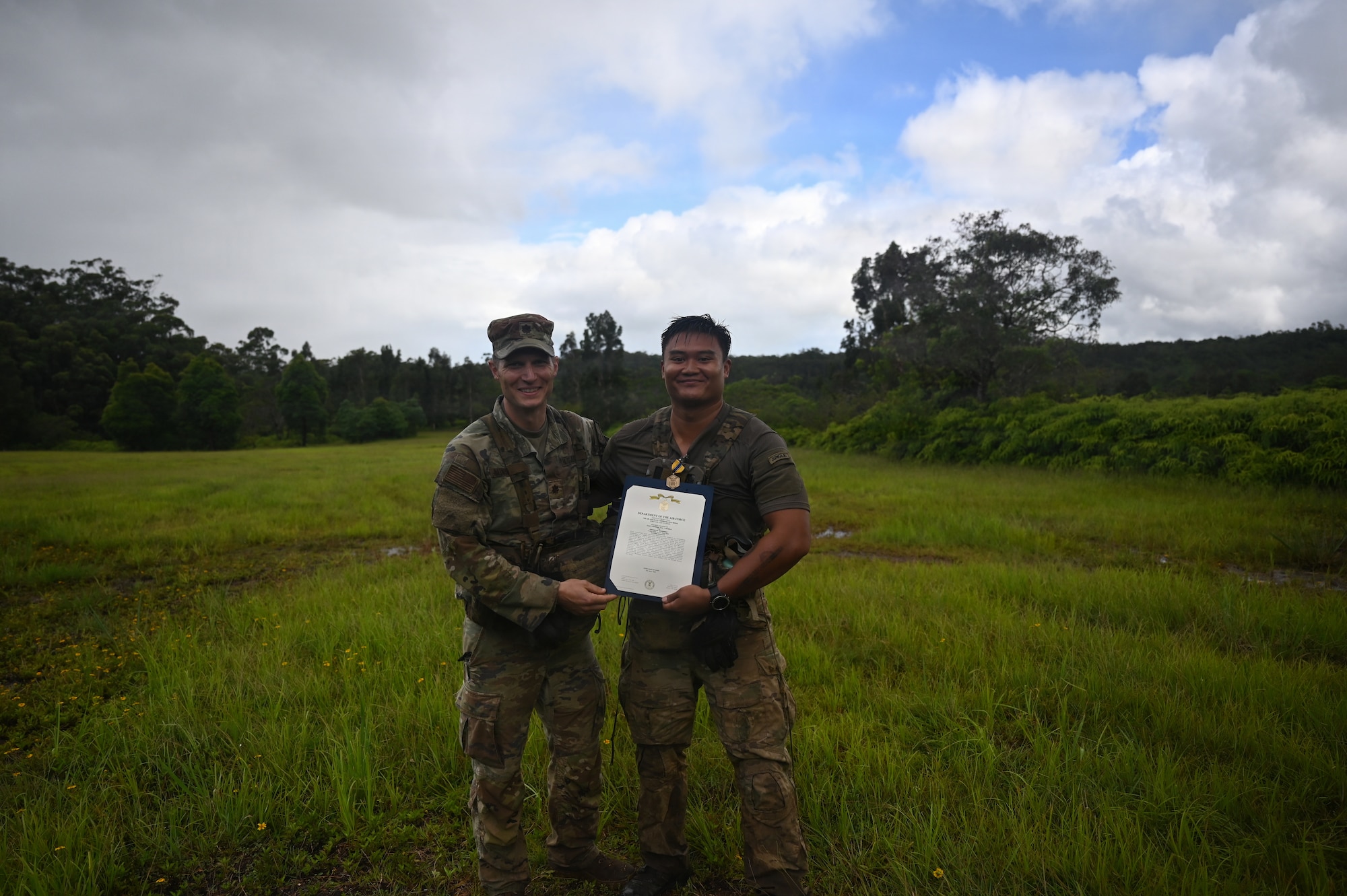 Maj. Eric Minshaw, commander of the 178th Security Forces Squadron, and 1st Lt. Kyle Mackerig, a guest jungle instructor from the 820th Base Defense Group at Moody Air Force Base, Georgia, pose with Mackerig's Air and Space Commendation Medal following an award presentation at the conclusion of annual training at Schofield Barracks, Hawaii, July 23, 2026. Mackerig was recognized for his contributions to the training and instruction of 178th Security Forces Airmen. (U.S. Air National Guard photo by Tech. Sgt. Tiffany Scofield)