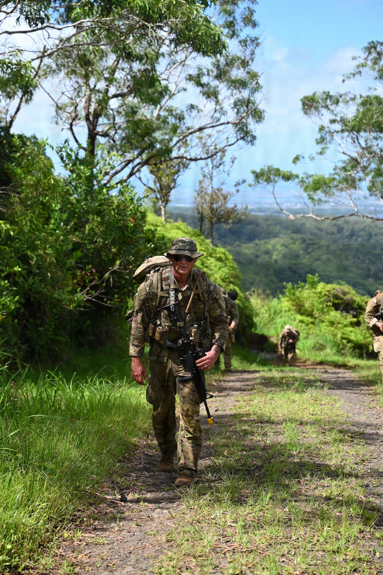 A Security Forces Airman assigned to the Ohio Air National Guard's 178th Security Forces Squadron hikes through the jungle terrain during annual training at Schofield Barracks, Hawaii, July 19, 2026. The training challenges Airmen to strengthen tactical proficiency, teamwork and expeditionary readiness while operating in unfamiliar terrain and austere conditions. (U.S. Air National Guard photo by Tech. Sgt. Tiffany Scofield)
