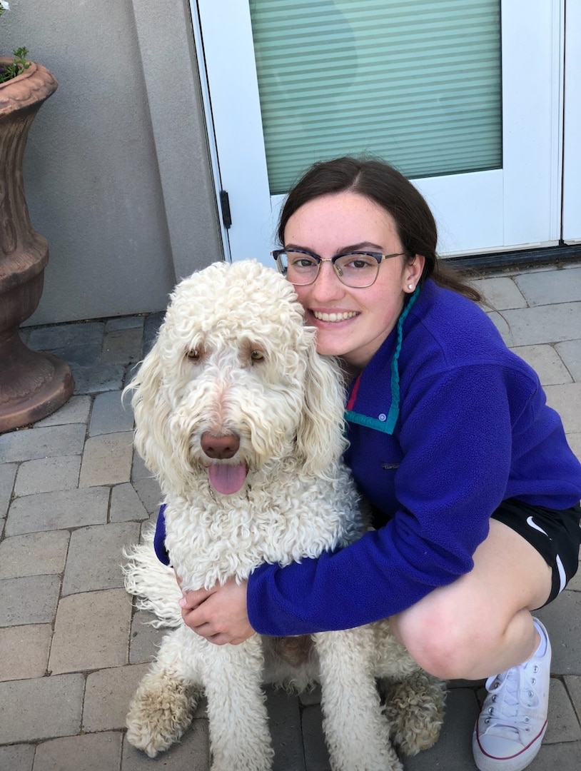 Katherine Bain poses for a photo with her family dog, Linus, a poodle mix. Bain recently left the Nevada Air National Guard to pursue veterinary school at Cornell University. Without her military service, Bain said she would not have been admitted to the Ivy League university.