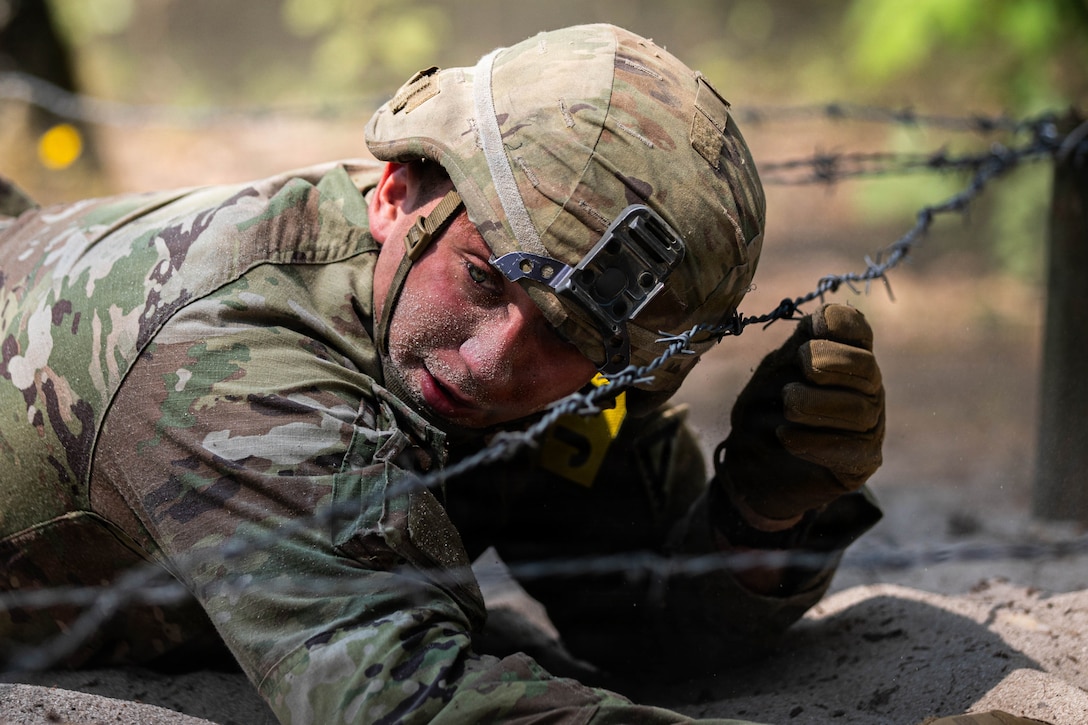 U.S. Army Spc. Brandon Pierce, with 7th Army Training Command, maneuvers through a barbed wire and sand obstacle course during the U.S. Army Europe and Africa Best Squad Competition at Grafenwoehr Training Area, Germany, July 31, 2026. Teams across U.S. Army Europe and Africa meet at Grafenwoehr Training Area, Germany, to compete for the title of Best Squad, July 30-August 6, 2026. The event tests the squad’s effectiveness, communication, and overall cohesion, as well as the individual Soldier’s technical and tactical proficiency, endurance, and fortitude. This competitive training event exercises a full range of squad-level skills, highlighting professional excellence and knowledge to determine the command’s top teams. Winners of this competition will advance to represent U.S. Army Europe and Africa at the Army Best Squad Competition. (U.S. Army Reserve photo by Sgt. Addison Shinn)