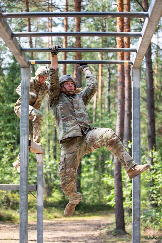 U.S. Army Spc. William Wertz, with 7th Army Training Command, maneuvers through the overhead traverse obstacle during the U.S. Army Europe and Africa Best Squad Competition at Grafenwoehr Training Area, Germany, July 31, 2026. Teams across U.S. Army Europe and Africa meet at Grafenwoehr Training Area, Germany, to compete for the title of Best Squad, July 30-August 6, 2026. The event tests the squad’s effectiveness, communication, and overall cohesion, as well as the individual Soldier’s technical and tactical proficiency, endurance, and fortitude. This competitive training event exercises a full range of squad-level skills, highlighting professional excellence and knowledge to determine the command’s top teams. Winners of this competition will advance to represent U.S. Army Europe and Africa at the Army Best Squad Competition. (U.S. Army Reserve photo by Sgt. Addison Shinn)