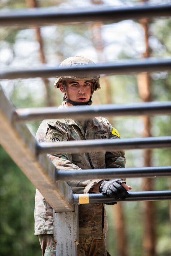 U.S. Army Sgt. Dustin Moore, with 7th Army Training Command, prepares to attempt the overhead traverse obstacle during the U.S. Army Europe and Africa Best Squad Competition at Grafenwoehr Training Area, Germany, July 31, 2026. Teams across U.S. Army Europe and Africa meet at Grafenwoehr Training Area, Germany, to compete for the title of Best Squad, July 30-August 6, 2026. The event tests the squad’s effectiveness, communication, and overall cohesion, as well as the individual Soldier’s technical and tactical proficiency, endurance, and fortitude. This competitive training event exercises a full range of squad-level skills, highlighting professional excellence and knowledge to determine the command’s top teams. Winners of this competition will advance to represent U.S. Army Europe and Africa at the Army Best Squad Competition. (U.S. Army Reserve photo by Sgt. Addison Shinn)