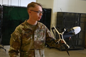 U.S. Army Sgt. Alexander Pagliro, Regimental Support Squadron, 2nd Cavalry Regiment, discussed his creative process for designing and building an interceptor drone from used parts and custom fabricated pieces during an open house at the 7th Army Training Command's  Design Innovation Research and Testing  Lab, Grafenwoehr, Germany, 31 July 2026. The DIRT Lab serves as a collaborative hub connecting Soldiers, engineers, and researchers to turn field-identified challenges into tangible solutions. Leveraging technologies like 3D printing, advanced manufacturing, robotics, and drones, empowering Soldiers to rapidly prototype and test capabilities designed by those closest to the challenges. (U.S. Army photo by Kevin Sterling Payne)