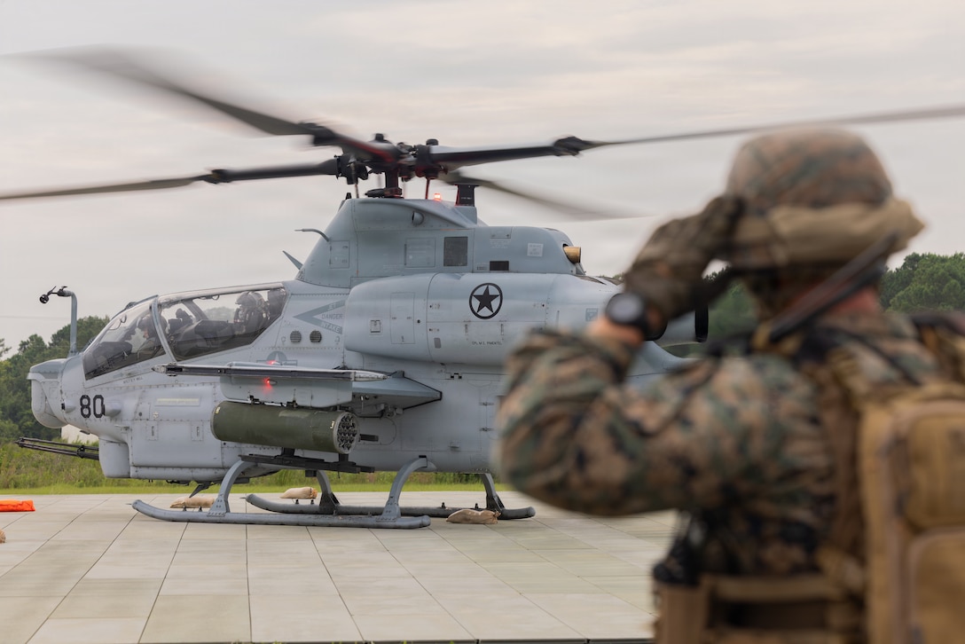 U.S. Marine Corps Cpl. Grant Smith, from Pennsylvania, a bulk fuel specialist with Marine Wing Support Squadron (MWSS) 271, Marine Air Control Group 28, 2nd Marine Aircraft Wing, observes an AH-1Z Viper with Marine Light Attack Helicopter Squadron (HMLA) 269, Marine Aircraft Group 29, 2nd MAW, land at a forward arming and refueling point at Marine Corps Auxiliary Landing Field Bogue, North Carolina, July 28, 2026. MWSS-272 hosted a two-week long aviation ground support leaders' course to provide leaders from across Marine Air Control Group 28 with a baseline knowledge of AGS capabilities to ensure continuity and operational readiness across 2nd MAW.