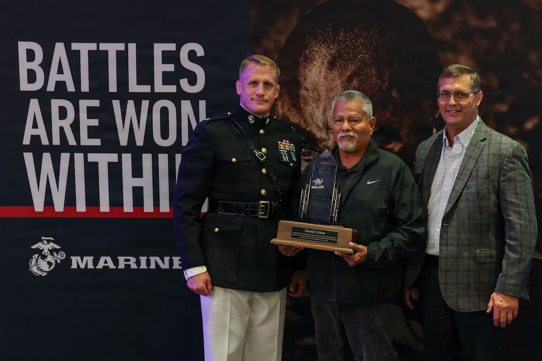 U.S. Marine Corps Lt. Col. Scott Steele, head of the Reserve Affairs Plans Section, Manpower and Reserve Affairs, left, stands with David Ochoa, head girl’s wrestling coach at Northview High School, center, and Mike Moyer, executive director of the National Wrestling Coaches Association, right, at the Battles Won Coach of the Year Awards during the 2026 National Wrestling Coaches Association Convention on July 31, 2026, in Baltimore. The Battles Won Award is a series of prestigious honors presented by the NWCA in partnership with the Marine Corps. The award recognizes head coaches, assistant coaches, and coaching staffs for outstanding leadership, character development, program growth, and impact beyond simply winning matches. (U.S. Marine Corps photo by Cpl. Brenna Ritchie)