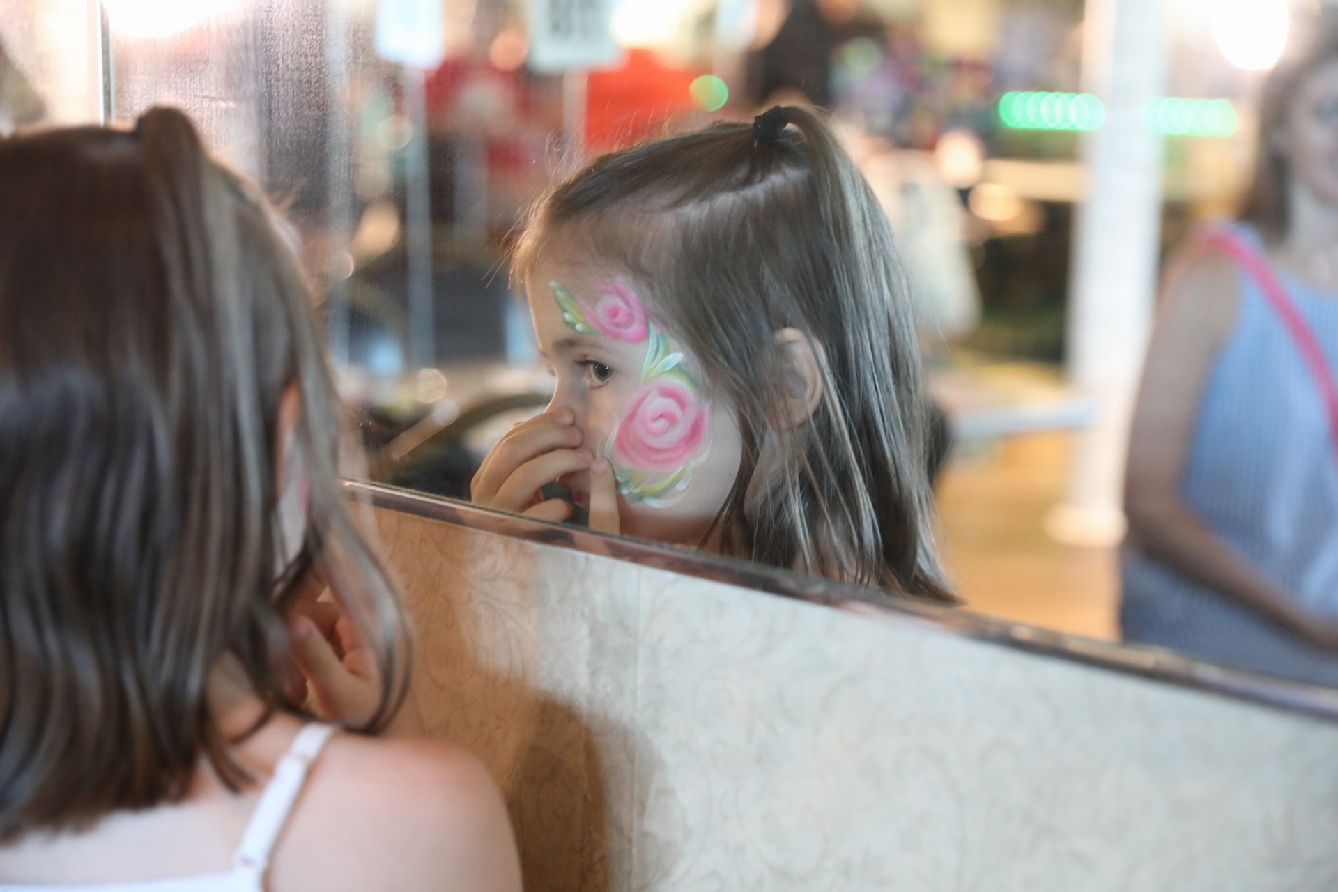 A child from a Gold Star family looks at her face paint in a mirror during the Survivor Outreach Services Riverboat Cruise in Cincinnati, Ohio, June 28, 2026.
