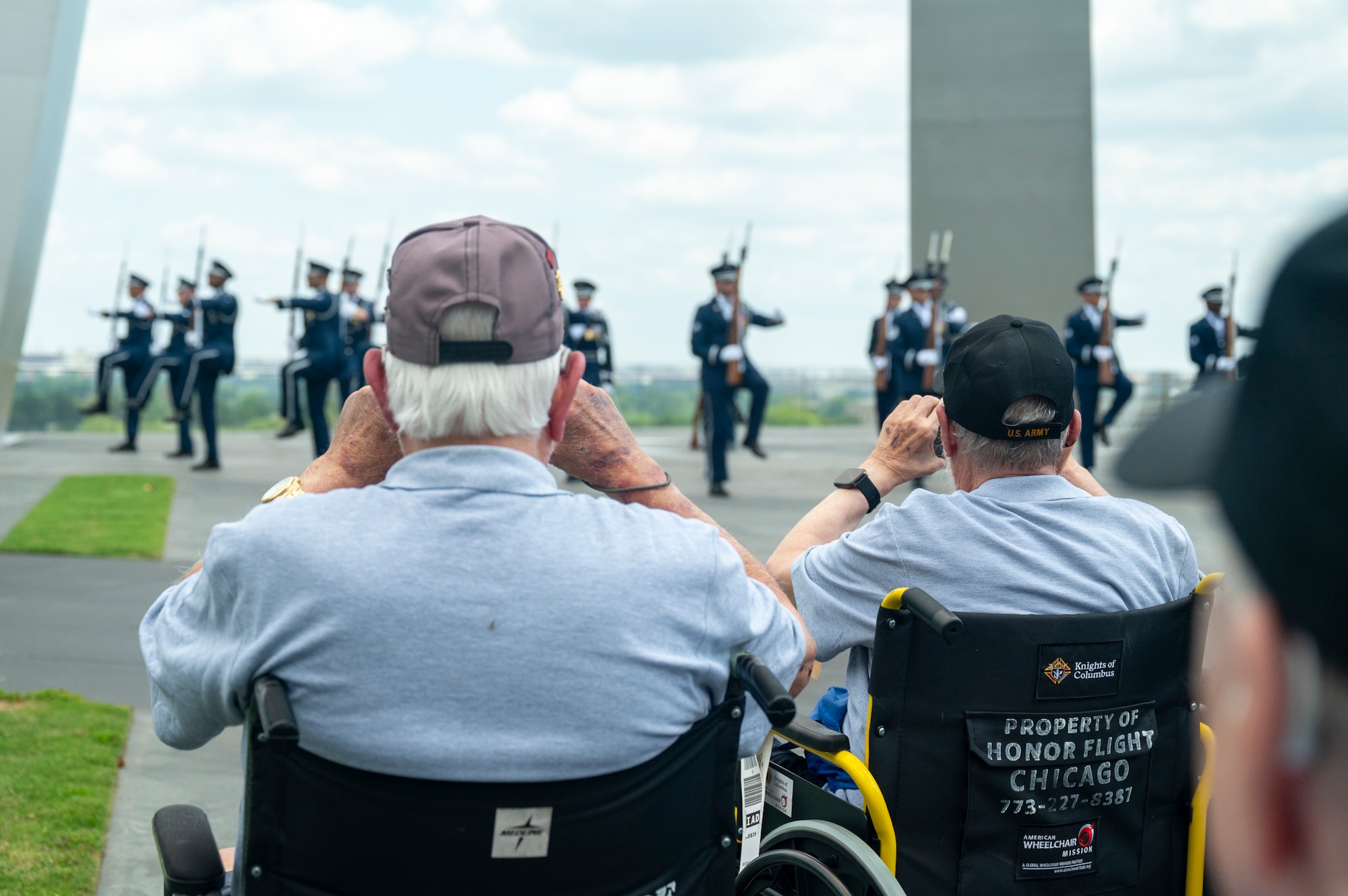 Veterans with Honor Flight Chicago photograph the U.S. Air Force Honor Guard Drill Team during a performance at the Air Force Memorial