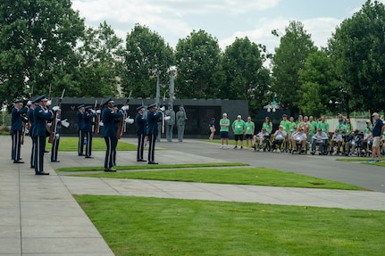 Ceremonial guardsmen with the U.S. Air Force Honor Guard Drill Team perform at the Air Force Memorial in front of veterans