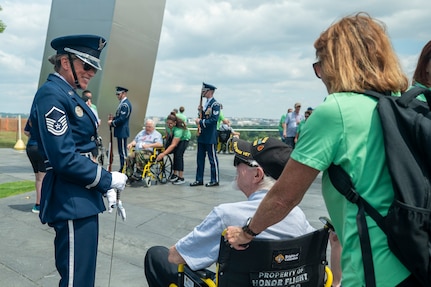 U.S. Air Force Honor Guard Drill Team flight chief, speaks with a veteran  in front of the Air Force memorial