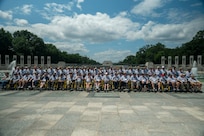 Veterans pose in front of the World War II memorial