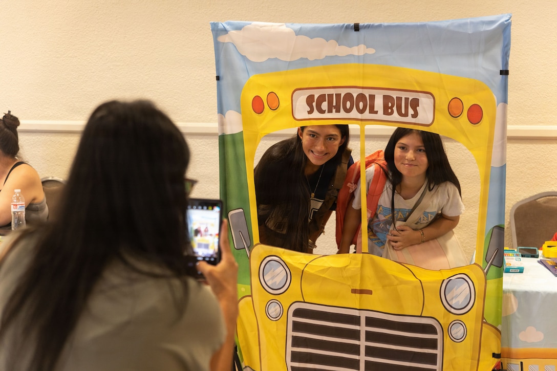 A family poses for a picture during the Back-to-School Resource Fair at Mojave Landing, Marine Corps Air Ground Combat Center, Twentynine Palms, California, July 23, 2026. The Back-to School Resource Fair allows families and students to meet important and integral parts of the community, while receiving free school supplies. (U.S. Marine Corps photo by Lance Cpl. Eliza Francka)