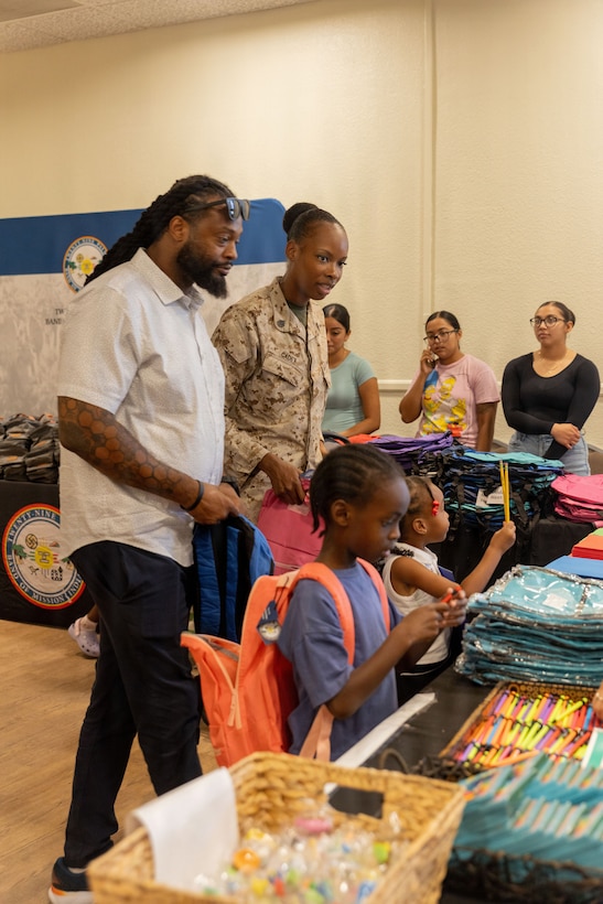 U.S. Marine Corps Staff Sgt. Jalisa Cadet, instructor with Air Control Tactics Squadron, Marine Corps Communications-Electronics School, Training and Education Command, receives school supplies during the Back-to-School Resource Fair at Mojave Landing, MCAGCC, Twentynine Palms, California, July 23, 2026. The Back-to School Resource Fair allows families and students to meet important and integral parts of the community, while receiving free school supplies. (U.S. Marine Corps photo by Lance Cpl. Eliza Francka)
