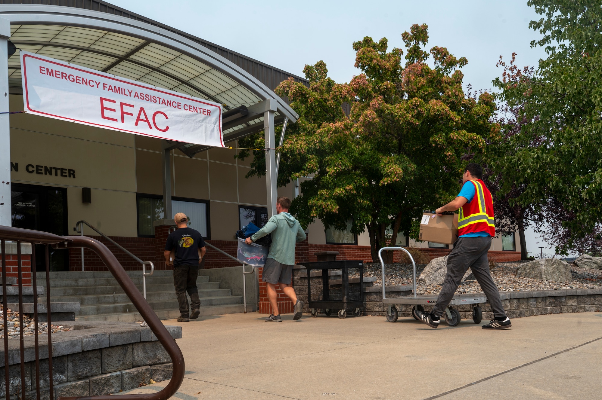 Volunteers for an Emergency Family Assistance Center transport donations on Fairchild Air Force Base, Washington.