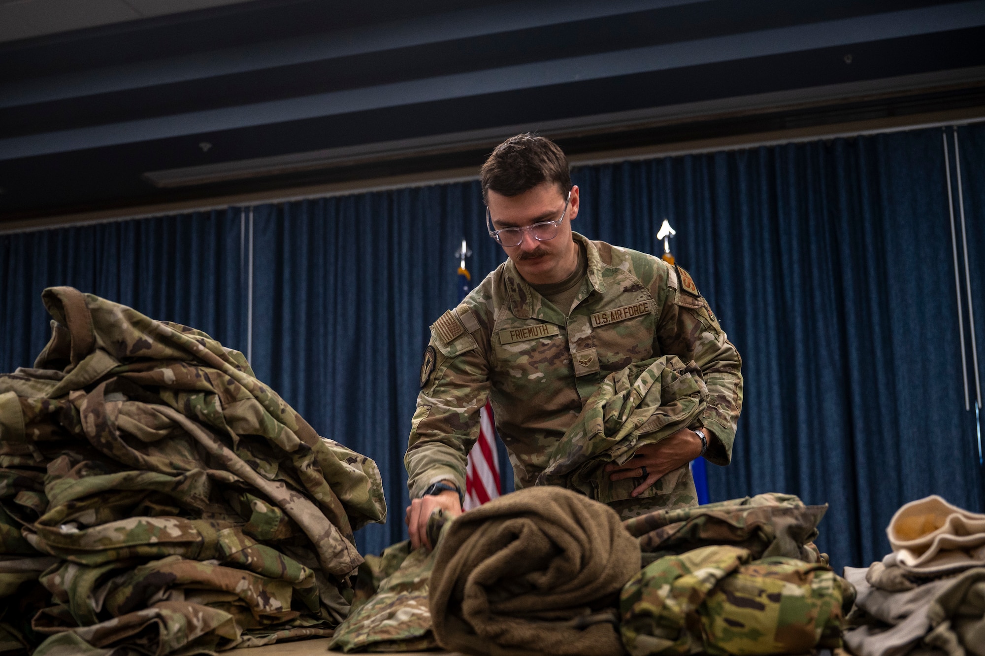 A volunteer for an Emergency Family Assistance Center folds donated clothes