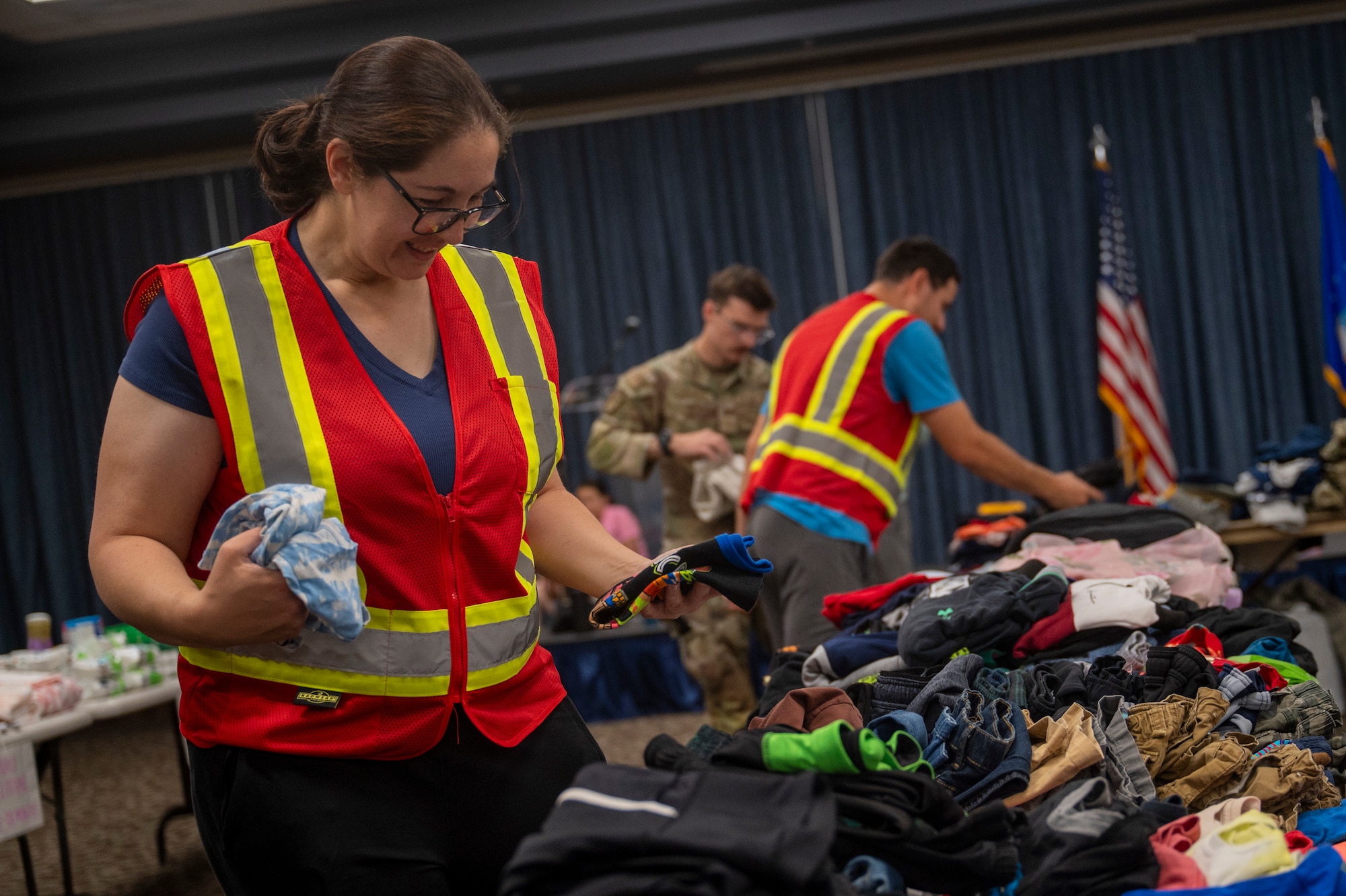 A volunteer for an Emergency Family Assistance Center folds donated clothes.