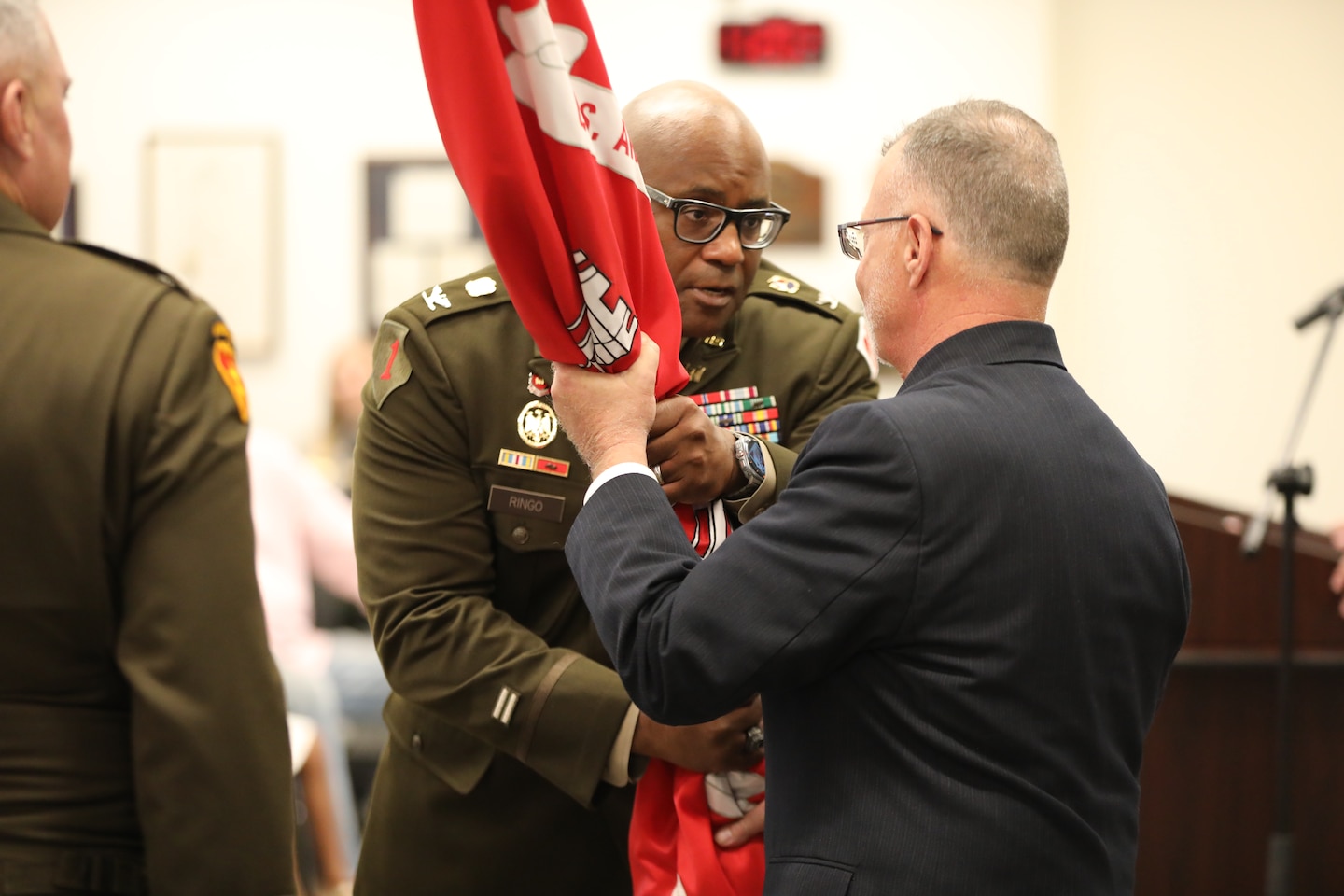 Col. Marlon Ringo completes a final passing of the colors to the senior civilian, Mr. Bob Hardberger, Deputy District Engineer, Programs and Project Management for the Fort Worth District, to signify the confidence that the commander places in the civilian work force to accomplish the mission.