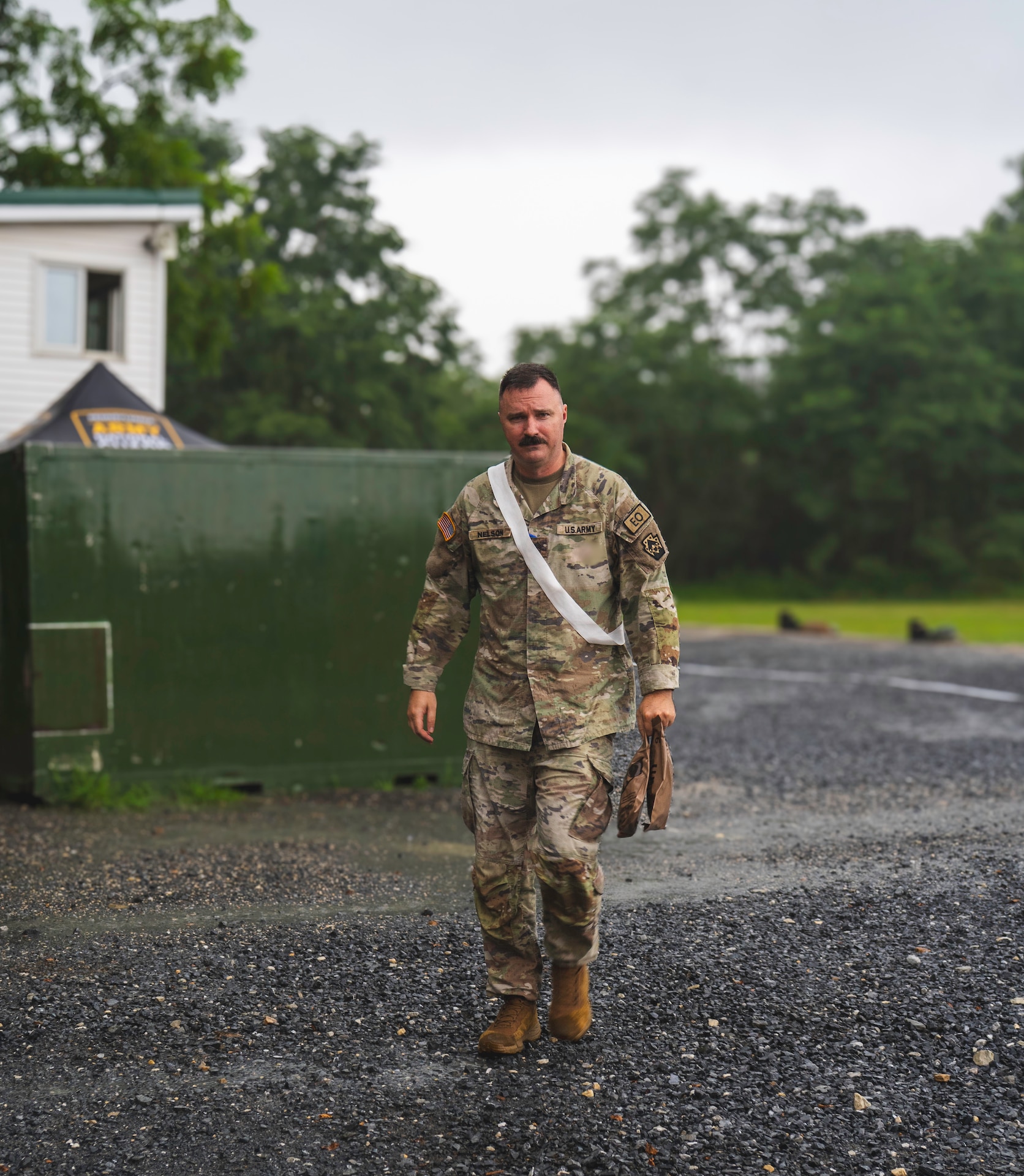 U.S. Army Sgt. 1st Class Brandon Nelson, assigned to the 109th Mobile Public Affairs Detachment, 213th Regional Support Group, Pennsylvania National Guard walks in the rain at a range on Fort Indiantown Gap, Pennsylvania, July 13, 2025. Nelson serves the 109th MPAD in multiple capacities mainly as the readiness noncommissioned officer. (U.S. Army National Guard photo by Sgt. Ashon Calhoun).