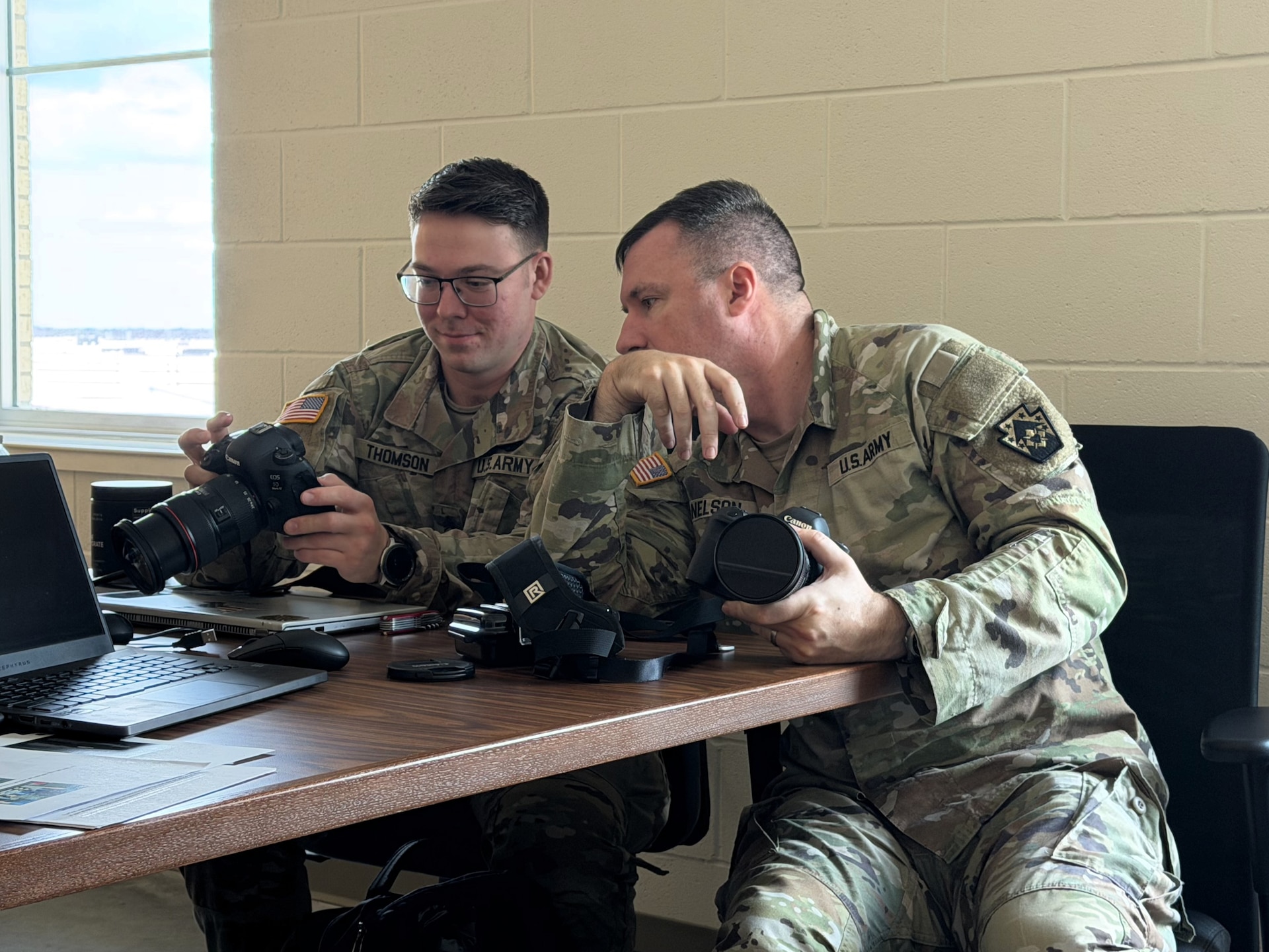 U.S. Army Sgt. 1st Class Brandon Nelson, right, a public affairs specialist with the 109th Mobile Public Affairs Detachment, shows the features and settings of a camera to Sgt. Dave Thomson during a class on photography techniques at their mobilization station at Fort Hood, Texas, Dec. 28, 2025. The unit is preparing to deploy to Europe in support of U.S. Special Operations Command Europe. (U.S. Army National Guard photo by Maj. Travis Mueller)