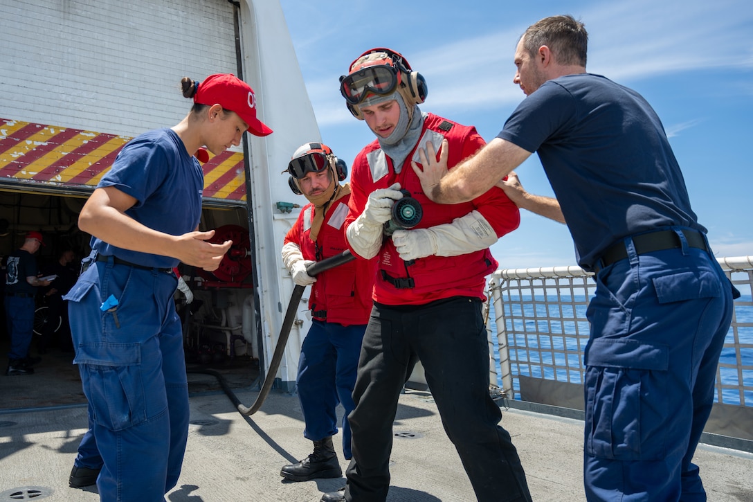 U.S. Coast Guardsmen go over fire suppression techniques during a simulated helicopter crash on the flight deck of Legend-class cutter USCGC Kimball (WMSL 756) in the Pacific Ocean during Exercise Rim of the Pacific 2026, July 13, 2026.