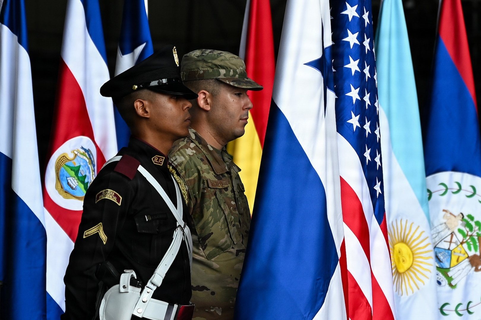 A U.S. Air Force service member holds the American flag next to a member of Panama’s Guardia Presidencial