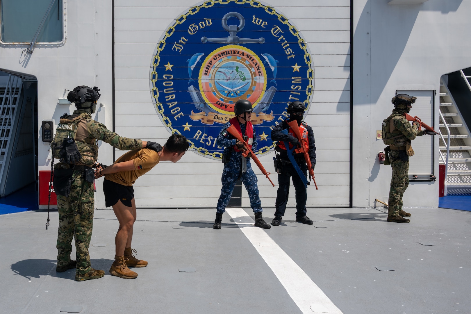 A Mexican marine is seen with a detained Philippine coast guardsman while a Mexican sailor, U.S. Coast Guard Ensign Jonathan Barrett, a law enforcement officer, and another Mexican marine provide cover during non-compliant vessel boarding training on Philippine Coast Guard Gabriela Silang-class offshore patrol vessel BRP Gabriela Silang (OPV 8301) in the Pacific Ocean, July 20, 2026.