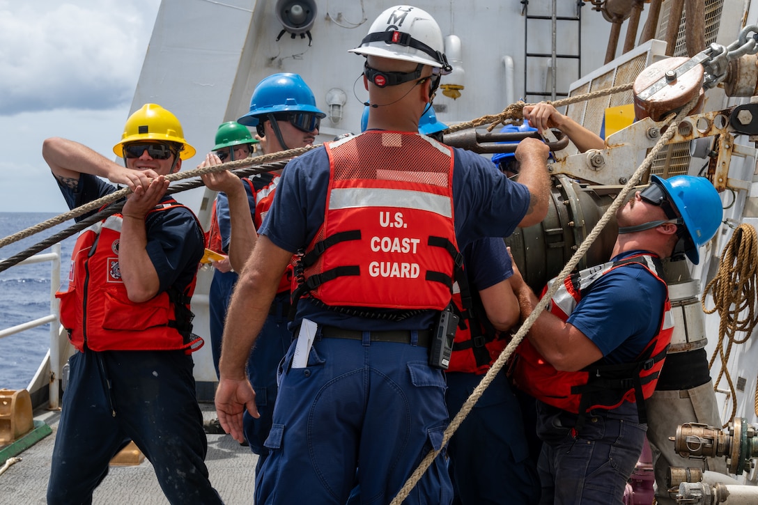 U.S. Coast Guard Petty Officer 1st Class Dean Casale, Petty Officer 3rd Class Hunter Franklin, Chief Petty Officer Matthew Jacobs, and Petty Officer 2nd Class Kamiah Olsen, boatswain’s mates, lift a fuel hose during a replenishment-at-sea operation in the Pacific Ocean, July 21, 2026.