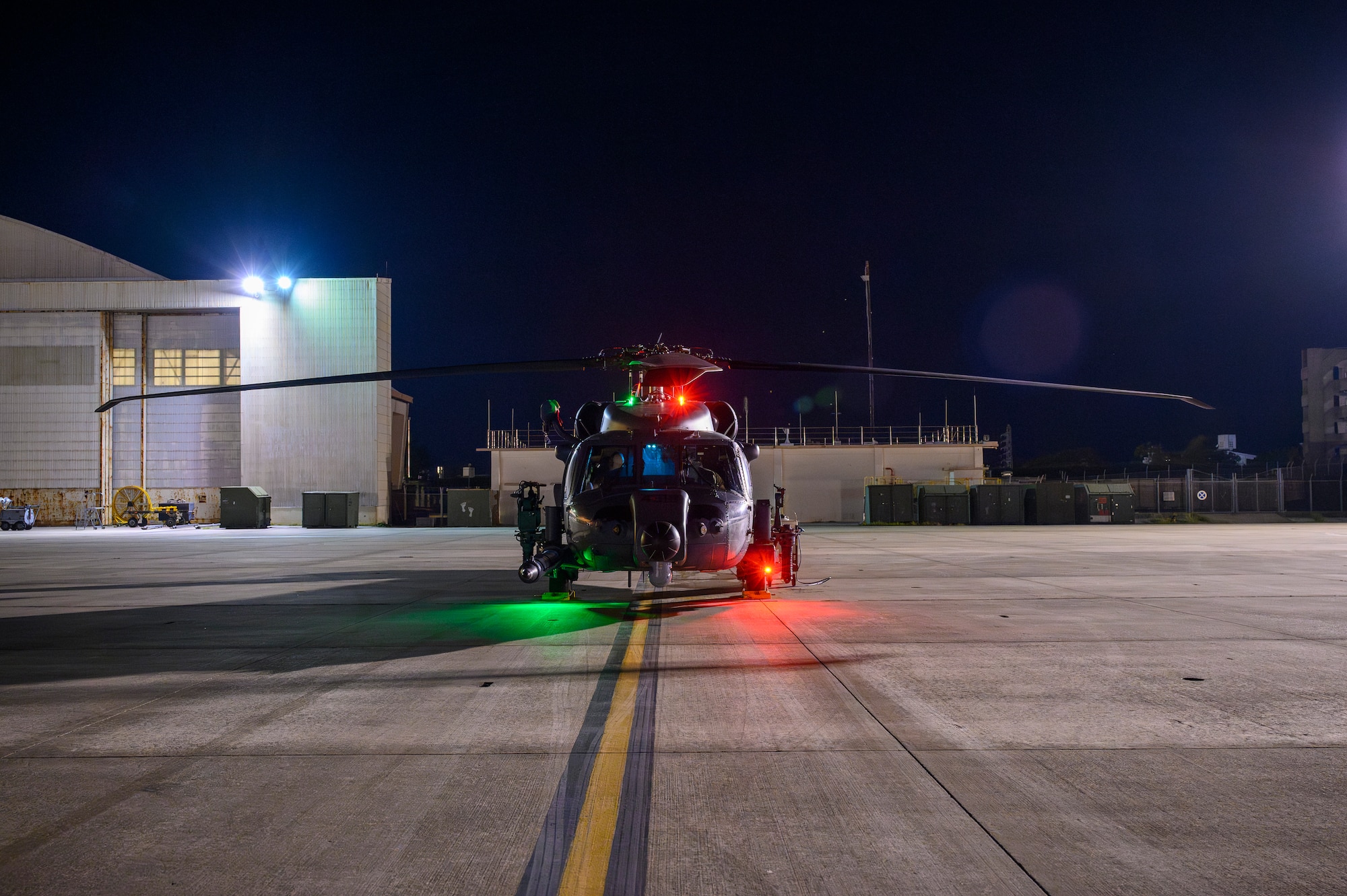 An HH-60W Jolly Green II assigned to the 33rd Rescue Squadron sits on the flightline during BB26-1 at Kadena Air Base, Japan, Aug. 3, 2026. Airmen prepared aircraft ahead of Typhoon Dolphin to preserve combat capability and ensure rescue assets remained ready to support potential evacuation and emergency response operations. (U.S. Air Force photo by Airman 1st Class Francisco Huerta)