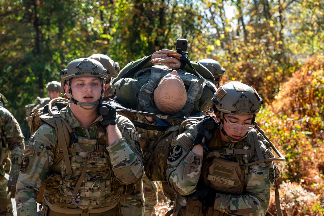 Military members carry ruck sacks while marching outside.