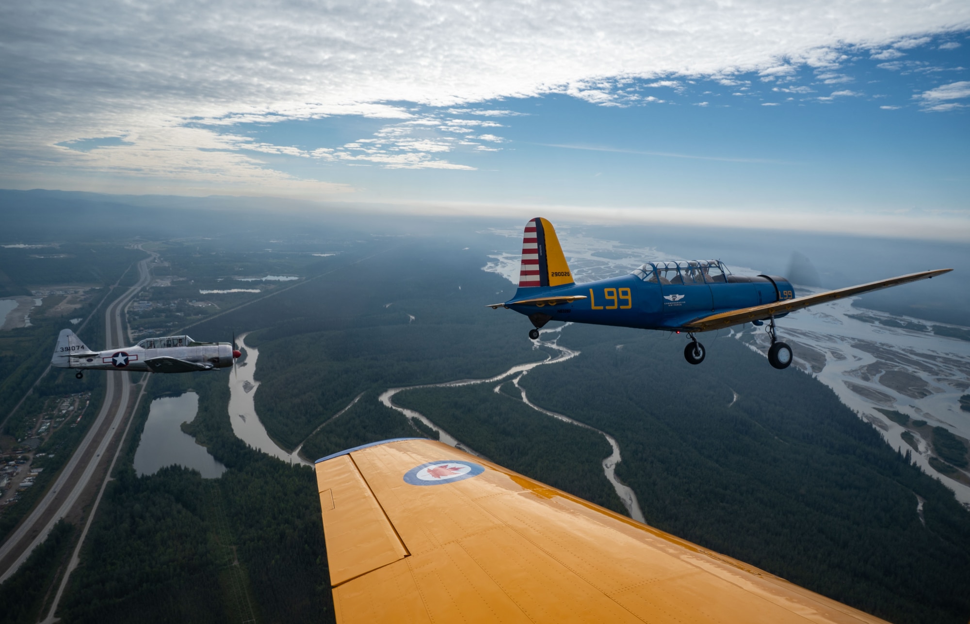 A BT-13 Valiant, top center, and a Harvard Mark IV (T-6) aircraft, from the Commemorative Air Force Alaska Wing, perform a flyover during the Arctic Lightning Air Show at Eielson Air Force Base, Alaska, July 31, 2026.