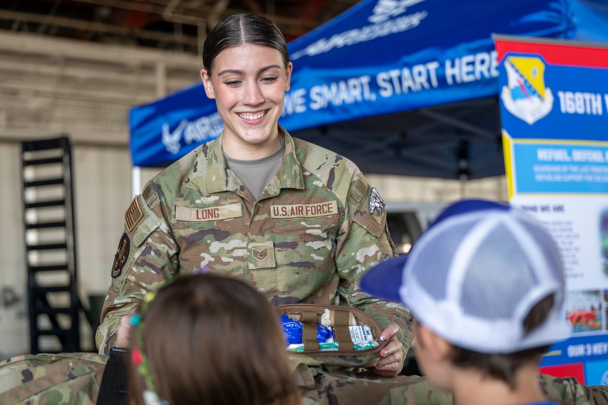U.S. Alaska Air National Guard Tech. Sgt. Sierra Long, 168th Medical Group aerospace medical technician, showcases a medical kit to visitors during the Arctic Lightning Air Show at Eielson Air Force Base, Alaska, Aug. 1, 2026.