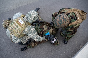 Service members simulat4e decontamination procedures.