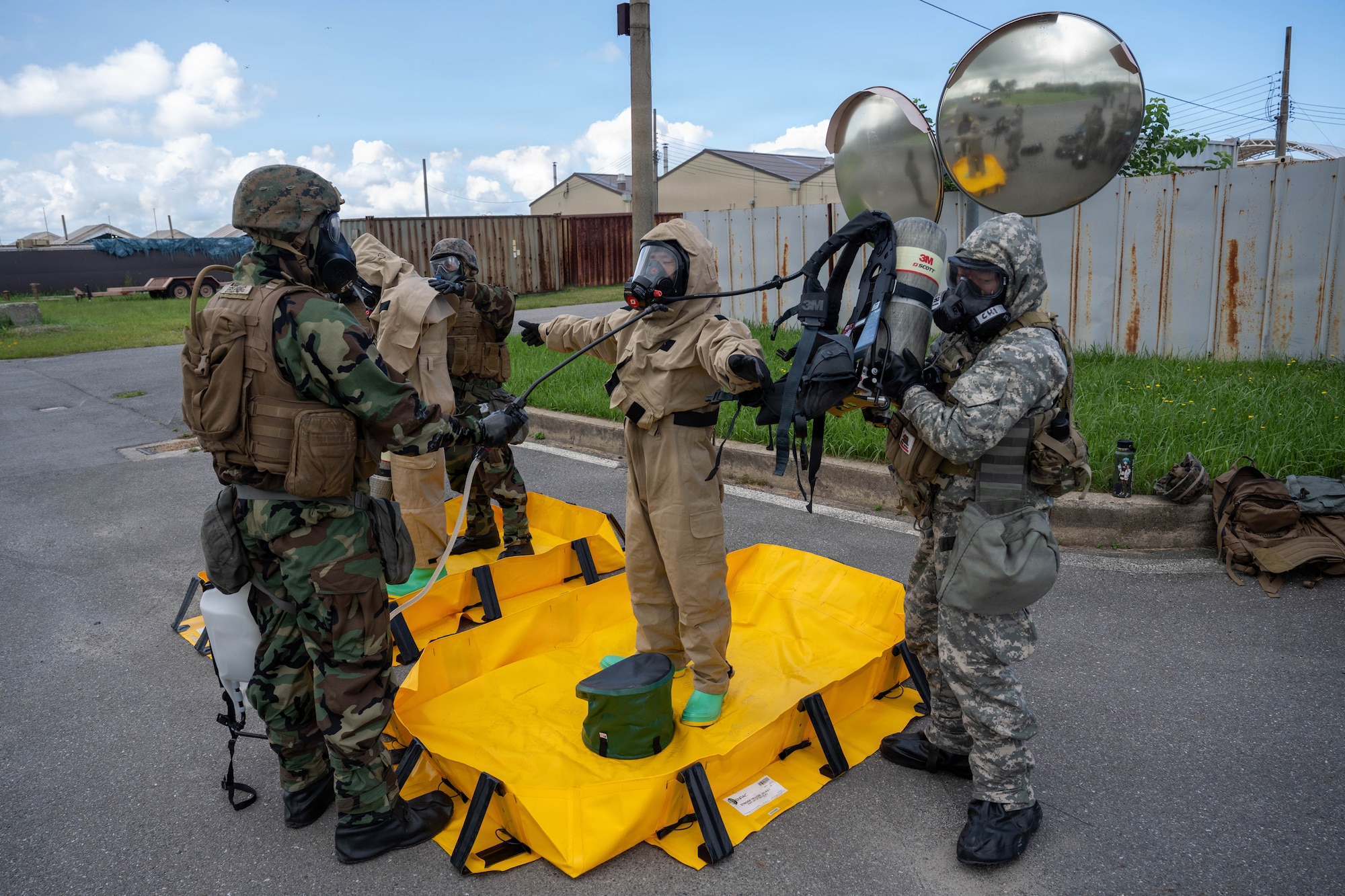 Service members simulate decontamination procedures.