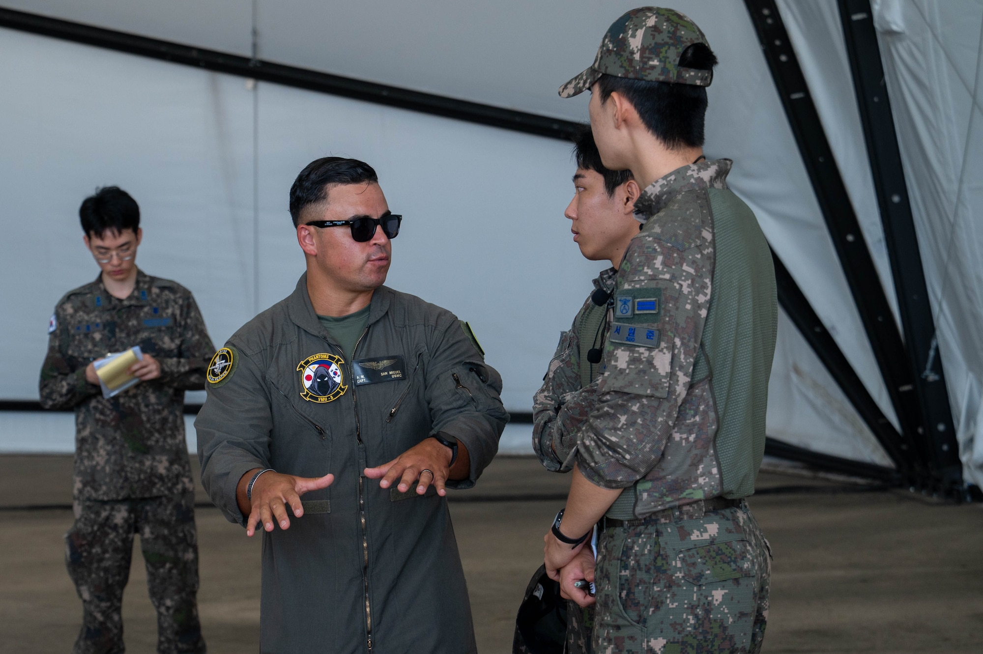 U.S. Marine Corps Capt. Aaron San Miguel, Marine Unmanned Vehicle Squadron (VMU) 3 MQ-9 Reaper pilot, and Republic of Korea Air Force Academy cadets converse during a tour at Kunsan Air Base, ROK, July 30, 2026. The visit provided an opportunity to engage with U.S. Air Force and U.S. Marine Corps service members while showcasing the teamwork and readiness that strengthen our combined defense. (U.S. Air Force photo by Staff Sgt. Cedrique Oldaker)