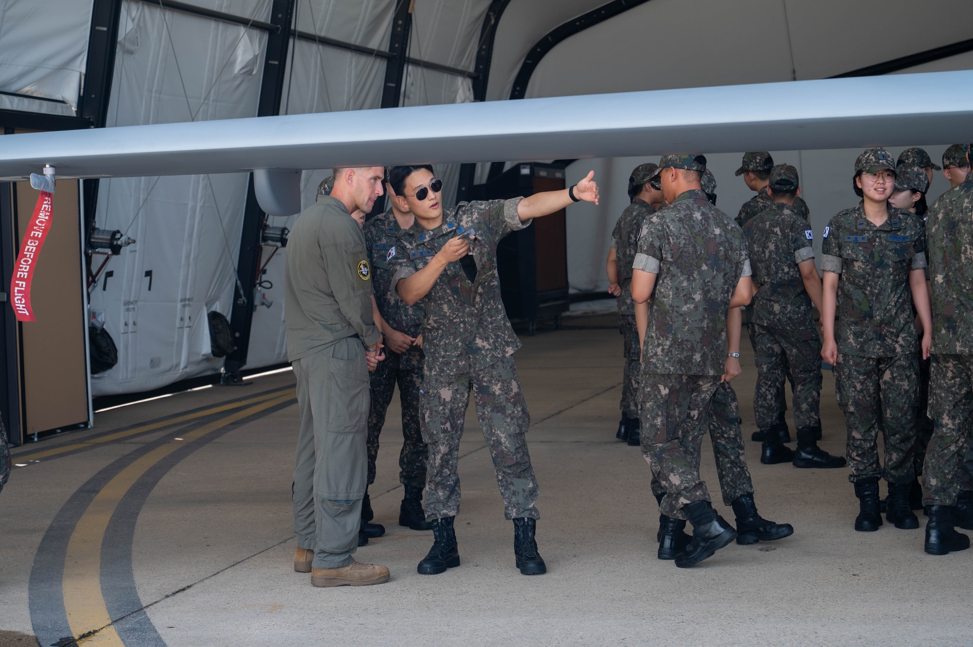 U.S. Marine Corps Capt. Ben Courter, Marine Unmanned Vehicle Squadron (VMU) 3 MQ-9 Reaper pilot, answers questions about the aircraft from a Republic of Korea Air Force Academy cadet during a tour at Kunsan Air Base, ROK, July 30, 2026. The tour reinforced the U.S.- ROK alliance, showing future ROKAF leaders the combined readiness and integrated defense capabilities that are vital to regional stability. (U.S. Air Force photo by Staff Sgt. Cedrique Oldaker)