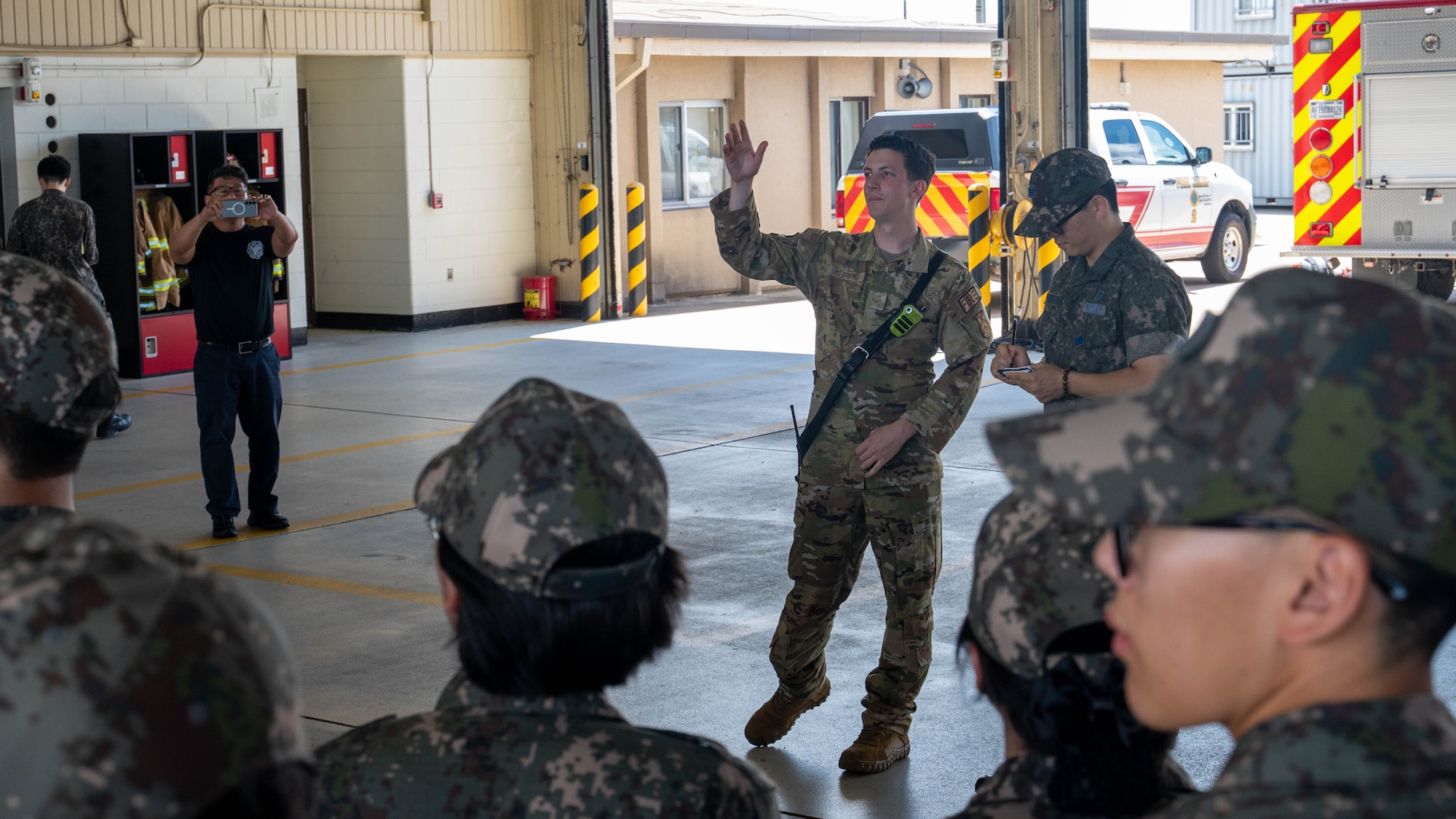 U.S. Air Force Airman 1st Class Patrick Serrano, 8th Civil Engineer Squadron firefighter, gives a tour of the firehouse engine bay to Republic of Korea Air Force Academy cadets at Kunsan Air Base, ROK, July 30, 2026. During the tour the cadets gained a deeper understanding of the mission, capabilities and interoperability that define the U.S.-ROK Alliance. (U.S. Air Force photo by Staff Sgt. Cedrique Oldaker)