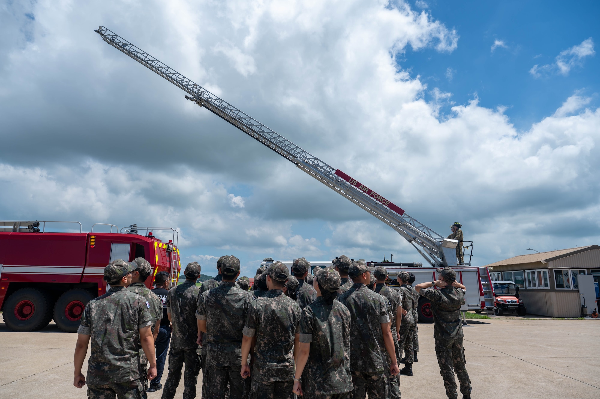 Republic of Korea Air Force Academy cadets watch a fire engine ladder demonstration during a tour at Kunsan Air Base, ROK, July 30, 2026. ROKAF Academy cadets were invited to Kunsan AB to gain insight on the mission, interoperability and joint capabilities between the U.S. and ROK alliance and to tour base facilities and assets. (U.S. Air Force photo by Staff Sgt. Cedrique Oldaker)