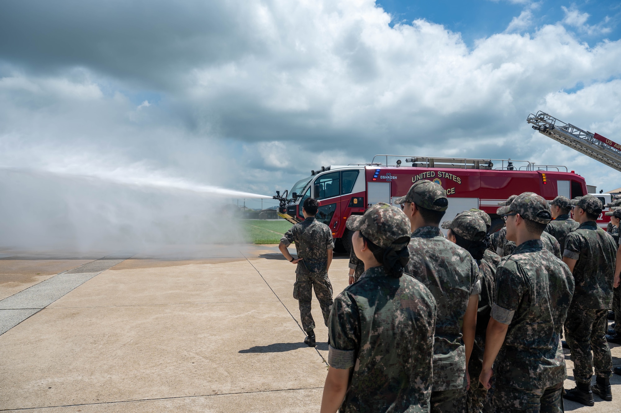 Republic of Korea Air Force Academy cadets watch a display of fire engine capabilities during a tour at Kunsan Air Base, ROK, July 30, 2026. The visit provided an opportunity for the cadets to engage with U.S. Air Force and U.S. Marine Corps service members while showcasing the teamwork and readiness that strengthen our combined defense. (U.S. Air Force photo by Staff Sgt. Cedrique Oldaker)