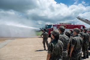 Republic of Korea Air Force Academy cadets watch a display of fire engine capabilities during a tour at Kunsan Air Base, ROK, July 30, 2026. The visit provided an opportunity for the cadets to engage with U.S. Air Force and U.S. Marine Corps service members while showcasing the teamwork and readiness that strengthen our combined defense. (U.S. Air Force photo by Staff Sgt. Cedrique Oldaker)