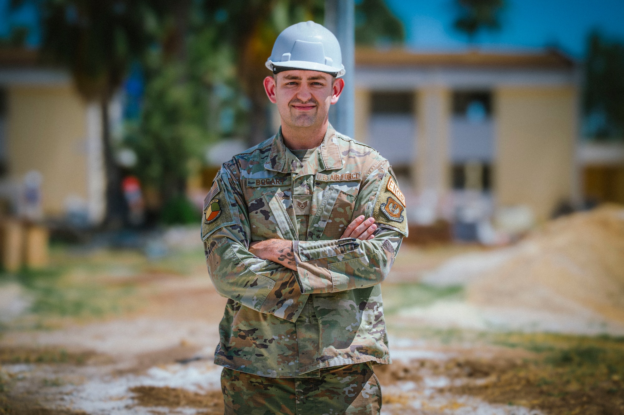 A military member with crossed arms, posing for a photo