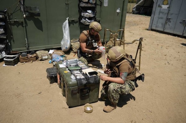 Hospital Corpsman 1st Class Jessika Gomez, a respiratory therapist assigned to Expeditionary Resuscitative Surgical System (ERSS) 5 from Navy Medicine Readiness and Training Command Guam, operates a tactical radio during an ERSS course conducted by the Naval Expeditionary Medicine Warfighter Development Center (NEMWDC), June 16, 2026. While serving primarily as a respiratory therapist, Gomez serves a dual role as a communications operator, demonstrating the critical adaptability required of Navy corpsmen. In expeditionary and resource-limited settings, a corpsman's ability to seamlessly pivot between specialized medical care and essential operational duties is vital to sustaining the force and ensuring mission success. (U.S. Navy photo by Petty Officer 1st Class Trevin Perry)