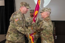 Photo of Col. Kilgore passing the unit colors to Sergeant Major Alkire.