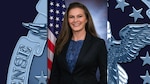 A woman posing in front of a flag.