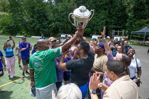 Sailors assigned to Navy Medicine Readiness and Training Command Bethesda, who were members of Team four aka Purple Team, hoist the 2026 NMRTC Bethesda Captain’s Cup trophy after winning the annual Captain’s Cup at Walter Reed National Military Medical Center, July 31, 2026. NMRTC Bethesda's mission is to maximize warfighter performance through optimized medical readiness tailored to operational requirements, enhance the readiness of the medical force to sustain expeditionary medical capability, and train and develop the Navy Medicine Force. (U.S. Navy photo by Mass Communication Specialist 2nd Class Alec Kramer)