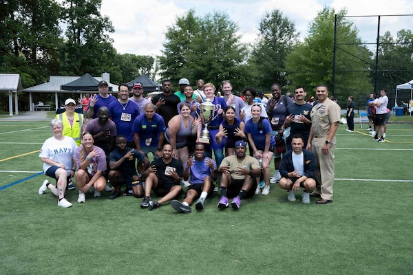 Sailors assigned to Navy Medicine Readiness and Training Command Bethesda, who were members of Team four aka Purple Team, pose for a photo with Capt. Darla Dietrich, commanding officer, NMRTC Bethesda and Command Master Chief Aaron Paul, hoisting the 2026 NMRTC Bethesda Captain’s Cup trophy after winning the annual Captain’s Cup at Walter Reed National Military Medical Center, July 31, 2026. NMRTC Bethesda's mission is to maximize warfighter performance through optimized medical readiness tailored to operational requirements, enhance the readiness of the medical force to sustain expeditionary medical capability, and train and develop the Navy Medicine Force. (U.S. Navy photo by Mass Communication Specialist 2nd Class Alec Kramer)